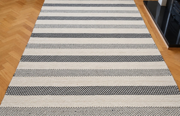 Black and ivory wool kilim rug with diamond and dotted stripe bands — retouched overview