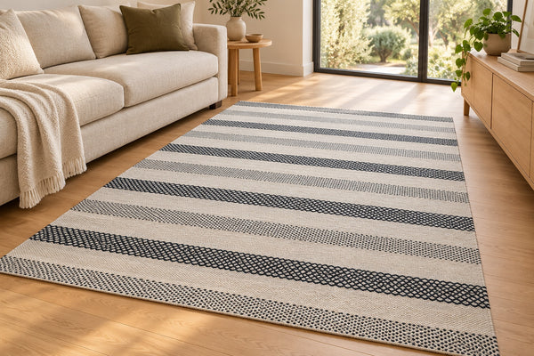Styled room illustration of the black and ivory diamond-stripe wool kilim rug in a modern living room